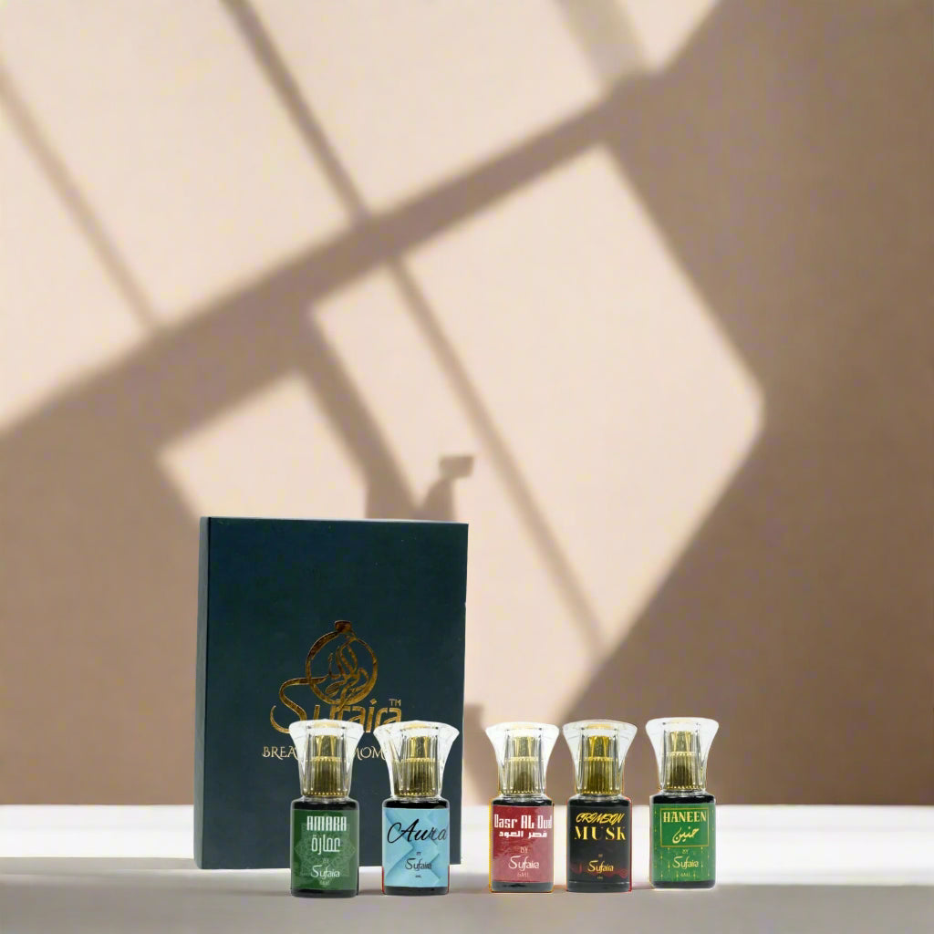 Five perfume bottles with a box labeled 'Sulaima' against a smoky background